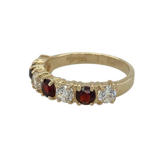 Bring rich colour and sparkling contrast to your collection with this pre-owned 9ct yellow gold band ring, designed with alternating garnet and cubic zirconia stones.

Design: The ring features a row of 4mm round garnets paired with brilliant cubic zirconia, creating a striking balance of deep red and bright sparkle.
Material: Made from 9-carat yellow gold, the polished finish enhances the warm tone and complements the vibrant gemstones. 