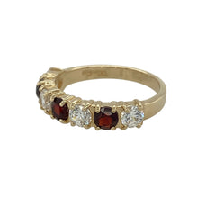 Load image into Gallery viewer, Bring rich colour and sparkling contrast to your collection with this pre-owned 9ct yellow gold band ring, designed with alternating garnet and cubic zirconia stones.

Design: The ring features a row of 4mm round garnets paired with brilliant cubic zirconia, creating a striking balance of deep red and bright sparkle.
Material: Made from 9-carat yellow gold, the polished finish enhances the warm tone and complements the vibrant gemstones. 
