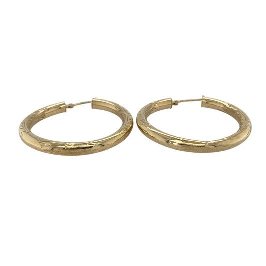 Bring bold detail and golden shine to your collection with these pre-owned 9ct yellow gold hoop earrings, styled in a classic creole design with patterned finish.

Design: Each earring features a traditional hoop shape with a decorative patterned surface, adding depth and character to the polished gold.
Material: Made from 9-carat yellow gold, the polished finish enhances the warm tone while highlighting the textured detailing.