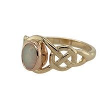 Load image into Gallery viewer, Bring heritage style and soft iridescence to your collection with this pre-owned 9ct yellow and rose gold Clogau ring, designed with a Celtic-inspired setting and an oval opalique stone.

Design: The ring showcases a 7mm by 5mm oval opalique at the centre, framed by a Celtic pattern that blends tradition with elegance.
Material: Made from 9-carat yellow and rose gold, the polished finish enhances the warm tones and highlights the intricate detailing.
