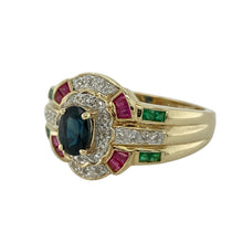Load image into Gallery viewer, Bring vibrant colour and striking design to your collection with this pre-owned 9ct yellow gold dress ring, featuring a bold mix of gemstones and sparkling diamonds.

Design: The front of the ring measures 16mm high and showcases an oval sapphire at the centre, framed by diamonds, with ruby and emerald detailing on the shoulders for added depth and contrast.
Material: Made from 9-carat yellow gold, the polished finish enhances the warm tone and complements the rich hues of the gemstones.
