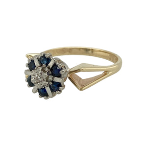 Add classic elegance to your collection with this pre-owned 9ct yellow gold sapphire and diamond cluster ring, a timeless piece with refined detail.

Design: The ring features a central diamond framed by a cluster of sapphires, each separated with touches of white gold to enhance contrast and definition.
Material: Made in 9-carat yellow gold with white gold accents, the polished finish complements the deep blue of the sapphires and the sparkle of the diamond.