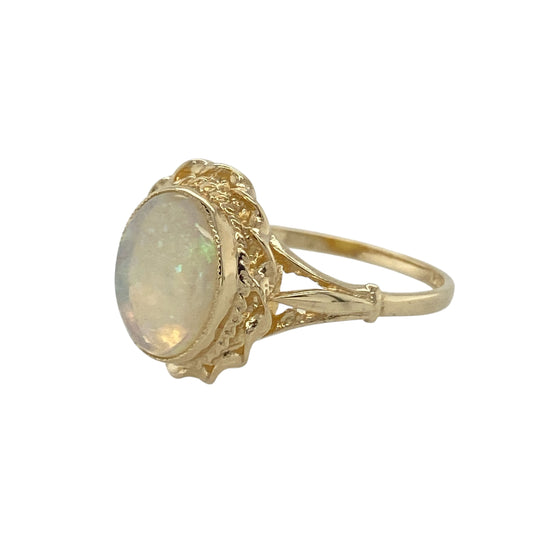 Bring soft colour and classic elegance to your collection with this pre-owned 9ct yellow gold opalique oval ring, a refined design enhanced by a traditional rope-style surround.

Design: The ring features an oval opalique stone measuring 10mm by 8mm, framed with a rope-style border that adds texture and timeless detail.
Material: Made from 9-carat yellow gold, the polished finish complements the iridescent tones of the opalique while providing a warm glow.