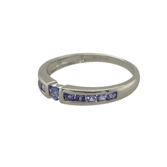 Bring subtle colour and refined elegance to your collection with this pre-owned 9ct white gold band ring, accented with a lavender-toned blue/purple stone for a graceful finish.

Design: The ring features a slim band accented with a single lavender-coloured stone, displaying delicate blue and purple hues for a soft and distinctive look.
Material: Made from 9-carat white gold, the polished finish enhances the cool tones of the band while complementing the gentle colour of the stone.