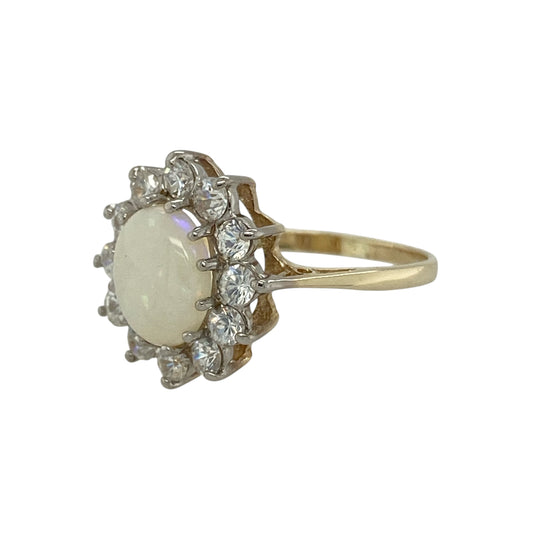 Bring shimmering colour and classic sparkle to your collection with this pre-owned 9ct yellow gold opalique and cubic zirconia cluster ring, a timeless design with elegant detail.

Design: The ring features an 8mm by 6mm oval opalique stone at the centre, surrounded by a cluster of cubic zirconia stones that enhance its iridescent tones with added brilliance.
Material: Made from 9-carat yellow gold, the polished finish complements the play of colour in the opalique while adding warmth and refinement.