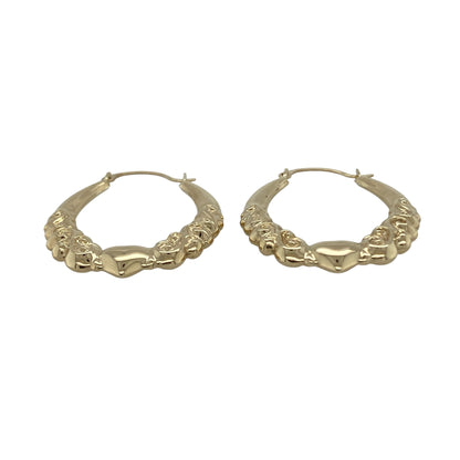 Bring romantic charm and classic style to your collection with these pre-owned 9ct yellow gold heart patterned oval creole earrings, a graceful design perfect for everyday wear or gifting.

Design: The earrings feature an oval creole shape decorated with a heart pattern, adding character and a touch of sentiment to a timeless style.
Material: Made from 9-carat yellow gold, the polished finish enhances the detailing while giving the earrings a warm glow.