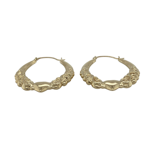 Bring romantic charm and classic style to your collection with these pre-owned 9ct yellow gold heart patterned oval creole earrings, a graceful design perfect for everyday wear or gifting.

Design: The earrings feature an oval creole shape decorated with a heart pattern, adding character and a touch of sentiment to a timeless style.
Material: Made from 9-carat yellow gold, the polished finish enhances the detailing while giving the earrings a warm glow.