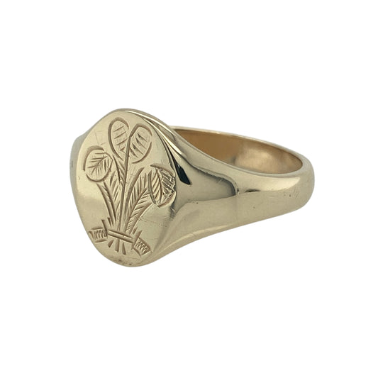 Bring bold detail and traditional style to your collection with this pre-owned 9ct yellow gold three feathers oval signet ring, a distinctive design with symbolic character.

Design: The ring features a 15mm high oval front engraved with a three feathers motif, adding heritage-inspired detail to a classic signet profile.
Material: Made from 9-carat yellow gold, the polished finish enhances the engraving while giving the piece a warm and refined glow.