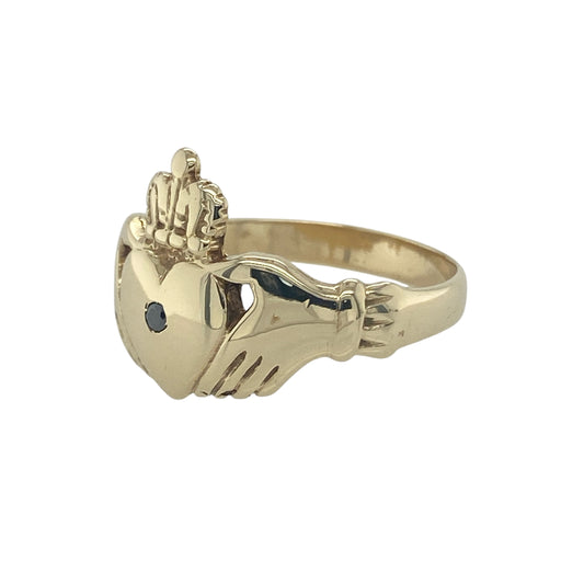 Bring symbolic meaning and striking detail to your collection with this pre-owned 9ct yellow gold black diamond Claddagh ring, a traditional design with a bold modern twist.

Design: The ring features the classic Claddagh motif—two hands holding a heart topped with a crown—measuring 15mm high, with a black diamond set at the centre for a distinctive finish.
Material: Made from 9-carat yellow gold, the polished band enhances the unique contrast of the dark gemstone against the warm gold.