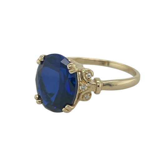 Bring bold colour and refined sparkle to your collection with this pre-owned 14ct yellow gold blue stone and cubic zirconia dress ring, a striking design with elegant detail.

Design: The ring features an 11mm by 9mm oval dark blue stone at the centre, complemented by sparkling cubic zirconia accents on the shoulders for added brilliance.
Material: Made from 14-carat yellow gold, the polished finish enhances the warm setting and beautifully contrasts with the deep blue of the stone.