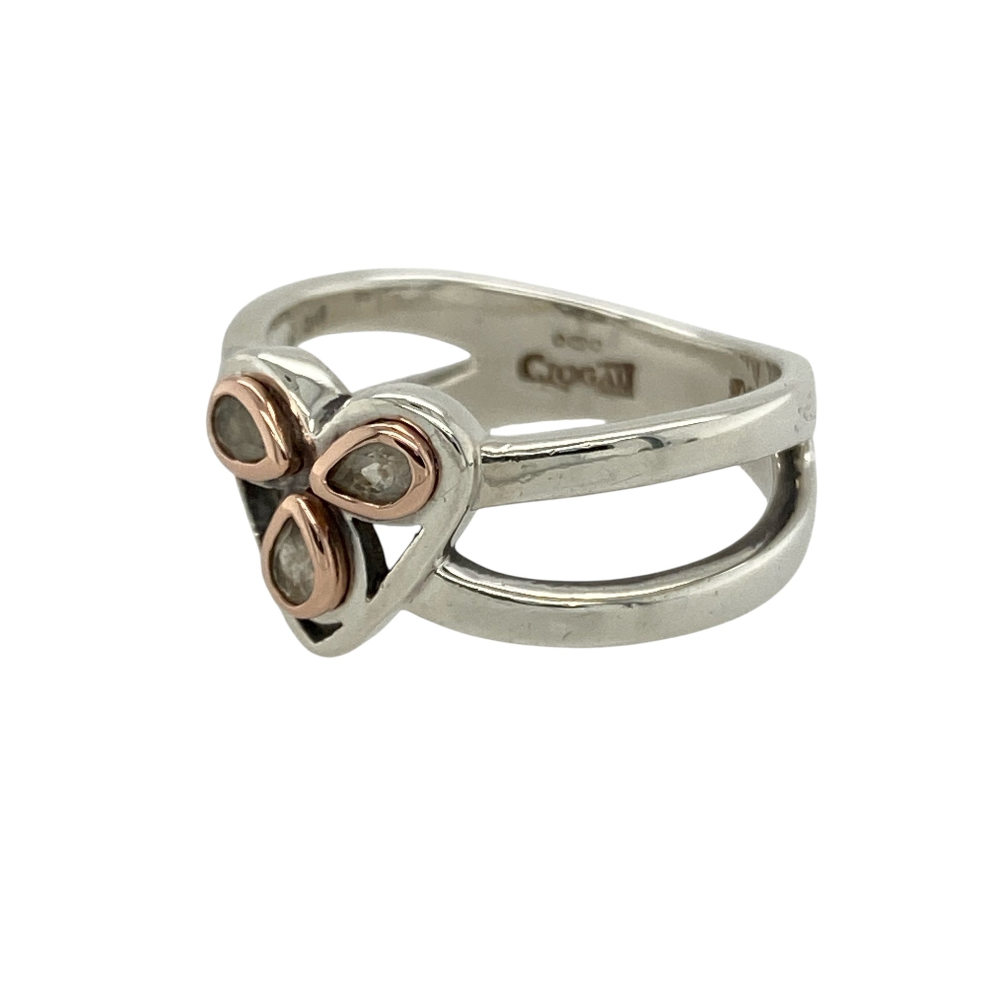 Bring romantic elegance and refined sparkle to your collection with this pre-owned Clogau heart ring in silver, 9ct rose gold, and white topaz—a meaningful design combining timeless charm with contemporary detail.

Design: The ring features a 10mm high heart motif set with white topaz stones, enhanced by 9ct rose gold accents and finished with split shoulders for added style.
Material: Made from 925 sterling silver