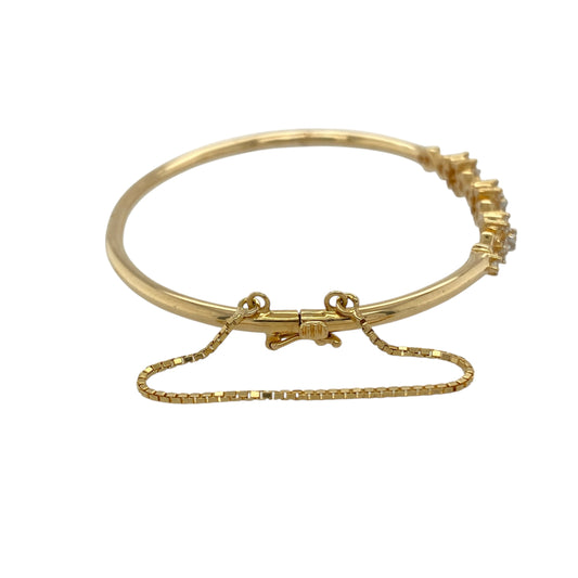 Bring timeless sparkle and floral elegance to your collection with this pre-owned 18ct yellow gold diamond flower cluster bangle—a refined piece combining beauty and sophistication.

Design: The bangle features a central flower cluster motif adorned with diamonds, adding brilliance and a touch of vintage-inspired charm. A fitted safety chain provides extra security while wearing.
Material: Made from 18-carat yellow gold, the polished finish enhances the warmth of the gold and the sparkle of the diamonds.