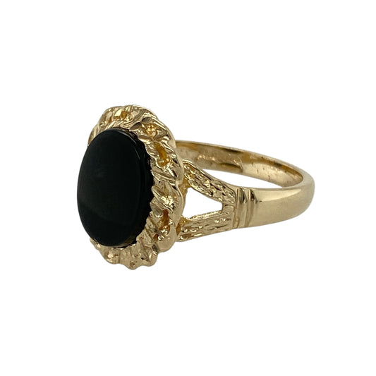 Bring vintage charm and bold contrast to your collection with this pre-owned 9ct yellow gold onyx ring, styled with a rope surround for added texture and detail.

Design: The ring features a 10mm by 8mm oval onyx stone framed by a decorative rope-style border, creating a striking and elegant focal point.
Material: Made from 9-carat yellow gold with an onyx centre, the polished finish enhances the deep black stone and the textured rope design.
