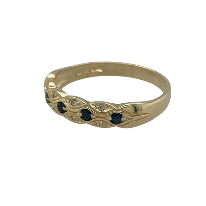 Bring refined colour and subtle sparkle to your collection with this pre-owned 9ct yellow gold sapphire and diamond patterned band ring—a classic design with elegant detail.

Design: The ring features a 5mm wide front with alternating sapphires and diamonds set into a patterned band, creating balance and contrast.
Material: Made from 9-carat yellow gold with sapphire and diamond accents, the polished finish enhances both the rich blue tones and the sparkle of the stones.