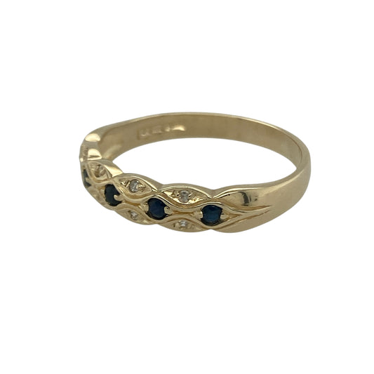 Bring refined colour and subtle sparkle to your collection with this pre-owned 9ct yellow gold sapphire and diamond patterned band ring—a classic design with elegant detail.

Design: The ring features a 5mm wide front with alternating sapphires and diamonds set into a patterned band, creating balance and contrast.
Material: Made from 9-carat yellow gold with sapphire and diamond accents, the polished finish enhances both the rich blue tones and the sparkle of the stones.