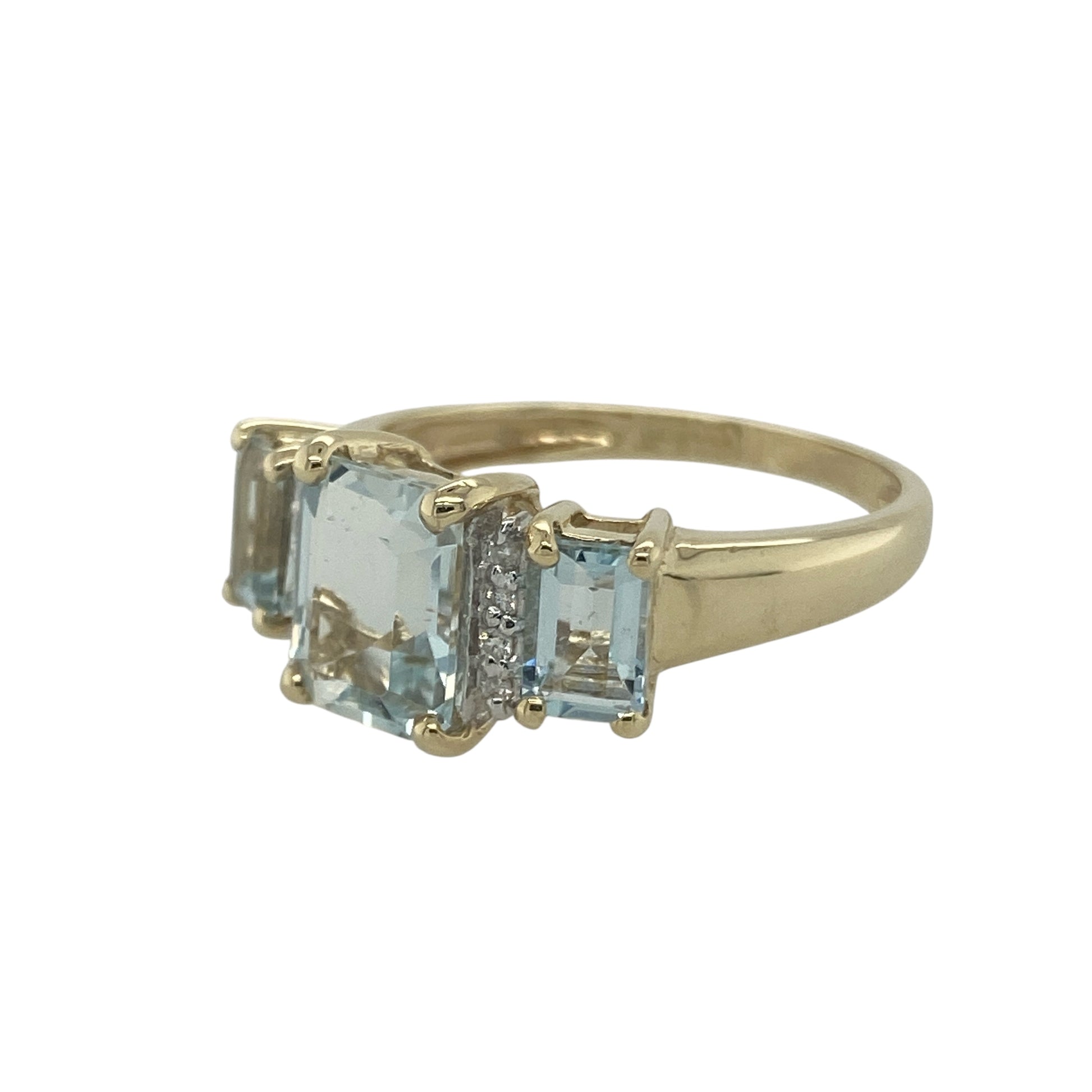 Bring refreshing colour and classic sparkle to your collection with this pre-owned 9ct yellow gold diamond and aqua trilogy ring, designed with elegance and timeless charm.

Design: The ring features three rectangular aqua stones, with the central stone measuring 9mm by 7mm, complemented by two smaller aqua stones on either side and accented with delicate diamonds in between.