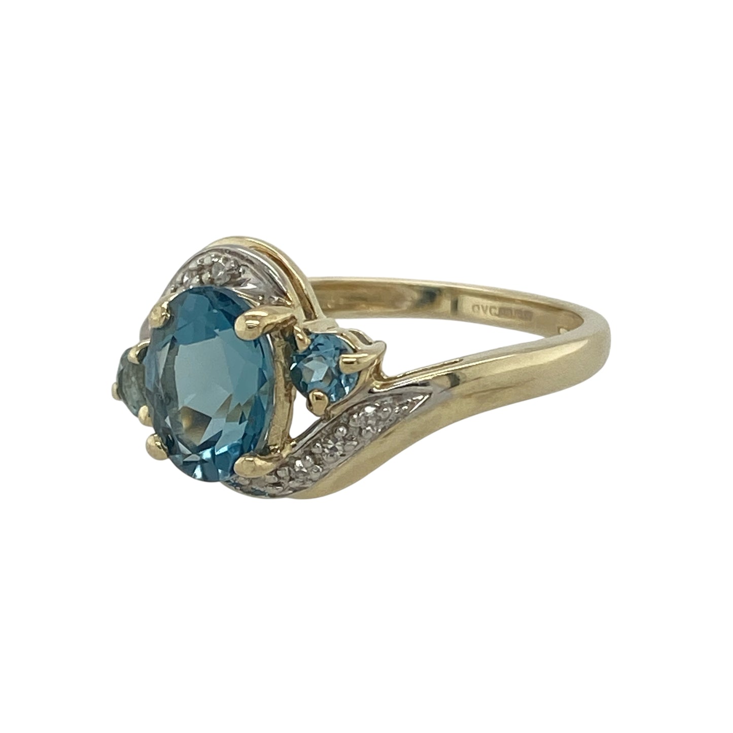 Bring radiant colour and graceful style to your collection with this pre-owned 9ct yellow gold diamond and blue topaz twist ring, blending elegance with a touch of sparkle.

Design: The ring showcases an 8mm by 6mm oval-cut blue topaz at the centre, flanked by two smaller round topaz stones and accented with diamonds along the twist design for added brilliance.
Material: Made from 9-carat yellow gold, the polished finish enhances the cool blue tones of the topaz and the sparkle of the diamonds.

