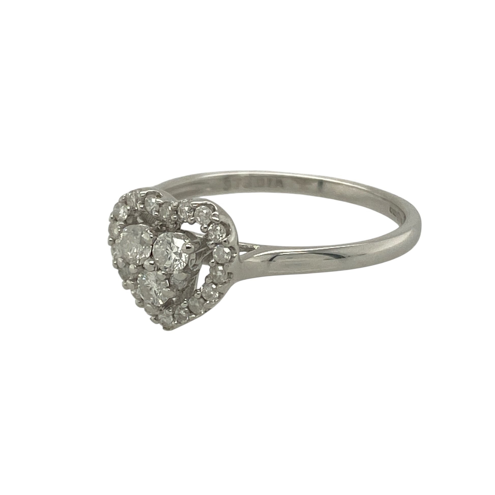 Bring romantic sparkle and timeless charm to your collection with this pre-owned 9ct white gold diamond heart cluster ring, a delicate design full of elegance and sentiment.

Design: The ring features a cluster of brilliant-cut diamonds arranged into a classic heart shape, creating a dazzling and symbolic centrepiece.
Material: Made from 9-carat white gold, the polished band enhances the brilliance of the diamonds and complements the romantic design.