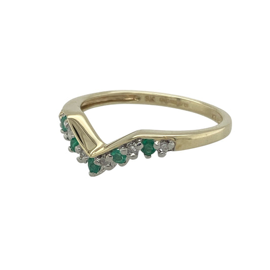 Bring graceful style and vibrant colour to your collection with this pre-owned 9ct yellow gold diamond and emerald wishbone ring, a delicate piece with timeless charm.

Design: The ring is styled in a wishbone shape, adorned with round emeralds of approximately 2mm diameter, accented by sparkling diamonds for added brilliance.
Material: Made from 9-carat yellow gold, the polished finish enhances the vivid green tones of the emeralds and the sparkle of the diamonds. 