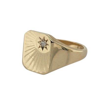 Bring bold style and refined detail to your collection with this pre-owned 9ct yellow gold diamond rectangle signet ring, designed with a classic star-set finish.

Design: The ring features a 13mm high rectangular front with a star-style design, accented by a sparkling diamond at the centre for added brilliance.
Material: Made from 9-carat yellow gold, the polished finish enhances the smooth surfaces and highlights the diamond detail.