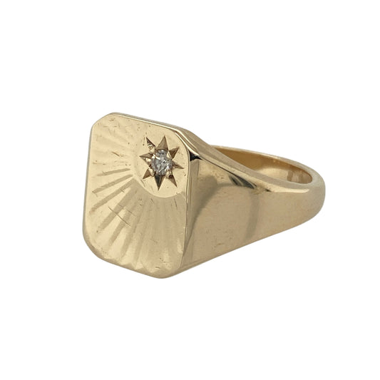Bring bold style and refined detail to your collection with this pre-owned 9ct yellow gold diamond rectangle signet ring, designed with a classic star-set finish.

Design: The ring features a 13mm high rectangular front with a star-style design, accented by a sparkling diamond at the centre for added brilliance.
Material: Made from 9-carat yellow gold, the polished finish enhances the smooth surfaces and highlights the diamond detail.