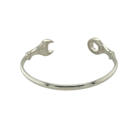 Bring playful style and sparkling detail to your collection with this new 925 silver cubic zirconia spanner torque bangle, a fun and fashionable design for children.

Design: The bangle features a torque style with a spanner-inspired design at the ends, accented with sparkling cubic zirconia stones for a touch of brilliance.
Material: Made from solid 925 sterling silver, the polished finish enhances the shine and gives a modern look.