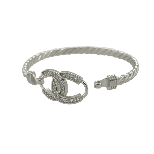 Bring sparkle and good fortune to your collection with this new 925 silver cubic zirconia children’s double horseshoe bangle, a charming design full of meaning and style.

Design: The bangle features a 12mm high front with two interlocking horseshoes, each accented with sparkling cubic zirconia stones for an elegant and eye-catching finish.
Material: Made from solid 925 sterling silver, the polished surface enhances the brilliance of the stones and gives the piece a bright, refined look.