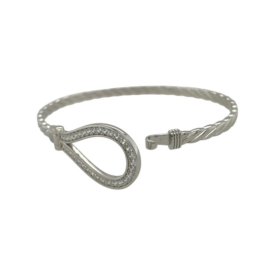 Bring timeless elegance and refined sparkle to your collection with this new 925 silver cubic zirconia horseshoe bangle, a graceful design symbolising luck and good fortune.

Design: The bangle features a 17mm high front with a classic horseshoe motif, beautifully accented with sparkling cubic zirconia stones for a bright and eye-catching finish.
Material: Made from solid 925 sterling silver, the polished surface enhances the shine and brilliance of the stones, giving the piece a sophisticated look.