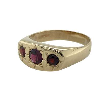 Bring rich colour and bold elegance to your collection with this pre-owned 9ct yellow gold garnet trilogy signet ring—a distinctive design combining classic form with deep, luxurious tones.

Design: The ring features a central round-cut garnet measuring 6mm in diameter, flanked by two smaller garnets in a refined trilogy arrangement that symbolises the past, present, and future. The deep red stones add warmth and sophistication to the bold signet style.