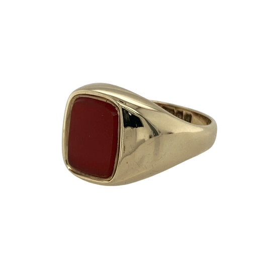 Bring warmth, style, and vintage charm to your collection with this pre-owned 9ct yellow gold carnelian signet ring—a refined piece that blends timeless design with rich, earthy colour.

Design: The ring features a rectangular carnelian gemstone measuring 9mm by 7mm, displaying its signature deep orange-red hue that symbolises vitality and strength. The smooth, polished surface gives the ring a sleek and elegant finish.