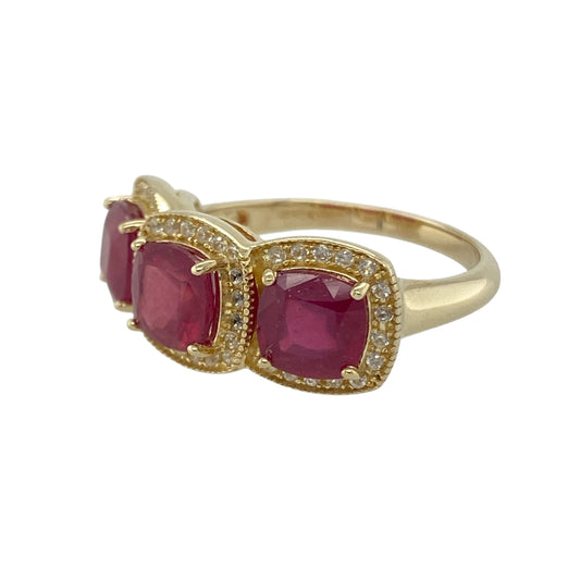 Bring rich colour and timeless sparkle to your collection with this pre-owned 9ct yellow gold diamond and ruby halo trilogy ring—a beautifully balanced design that radiates elegance and sophistication.

Design: The ring showcases three cushion-cut ruby gemstones, each surrounded by a halo of sparkling diamonds that enhance the vibrant red tones of the stones. The trilogy arrangement symbolises the past, present, and future, adding sentimental meaning to its refined beauty.