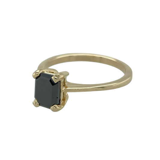 Bring bold elegance and contemporary style to your collection with this pre-owned 9ct yellow gold black diamond solitaire ring—a striking piece that blends modern sophistication with timeless design.

Design: The ring features an emerald-cut black diamond at its centre, offering a sleek and dramatic look. The clean lines of the emerald cut enhance the diamond’s depth and allure, creating a captivating statement piece.