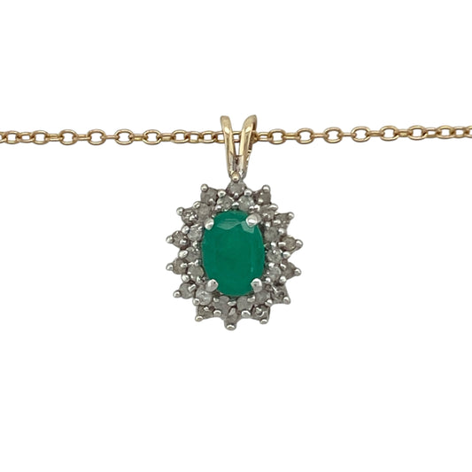 Bring vibrant colour and timeless elegance to your collection with this pre-owned 9ct yellow gold diamond and emerald cluster pendant on a 20" chain necklace—a beautifully classic design that radiates sophistication and charm.

Design: The pendant features a stunning oval-cut emerald at the centre, measuring approximately 7mm by 5mm, surrounded by a sparkling halo of diamonds that enhance the rich green hue of the gemstone.