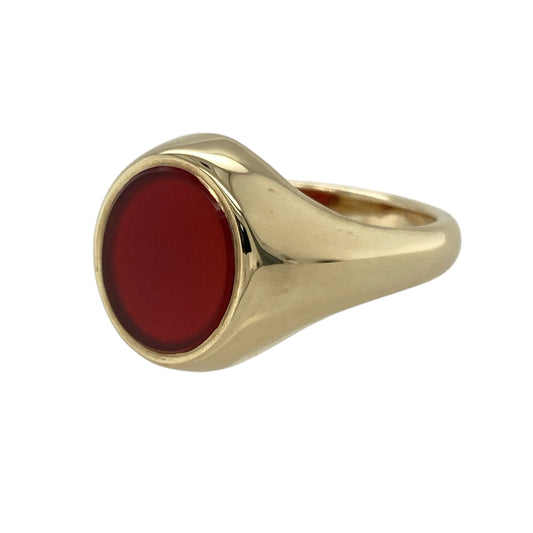 Bring bold elegance and classic style to your collection with this pre-owned 9ct yellow gold carnelian oval signet ring—a timeless design that combines refined craftsmanship with rich, natural colour.

Design: The ring features an oval-shaped carnelian stone measuring approximately 12mm by 10mm, displaying a warm reddish-brown hue that adds depth and sophistication. The smooth, polished surface of the gemstone gives the piece a clean, traditional look.