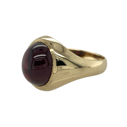 Bring rich colour and classic design to your collection with this pre-owned 9ct yellow gold red stone cabochon oval signet ring—a timeless piece that exudes elegance and character.

Design: The ring features a smooth oval cabochon-cut red stone measuring approximately 12mm by 10mm, offering a deep, lustrous tone that catches the light beautifully. The polished surface of the gemstone enhances its natural depth and warmth.