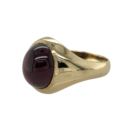 Bring rich colour and classic design to your collection with this pre-owned 9ct yellow gold red stone cabochon oval signet ring—a timeless piece that exudes elegance and character.

Design: The ring features a smooth oval cabochon-cut red stone measuring approximately 12mm by 10mm, offering a deep, lustrous tone that catches the light beautifully. The polished surface of the gemstone enhances its natural depth and warmth.