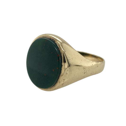 Bring distinctive style and rich colour to your collection with this pre-owned 9ct yellow gold and bloodstone signet ring, combining traditional design with bold character—perfect for everyday sophistication or special occasions.

Design: The ring features an oval bloodstone measuring 12mm by 10mm, showcasing deep green tones flecked with red for a striking and unique appearance.