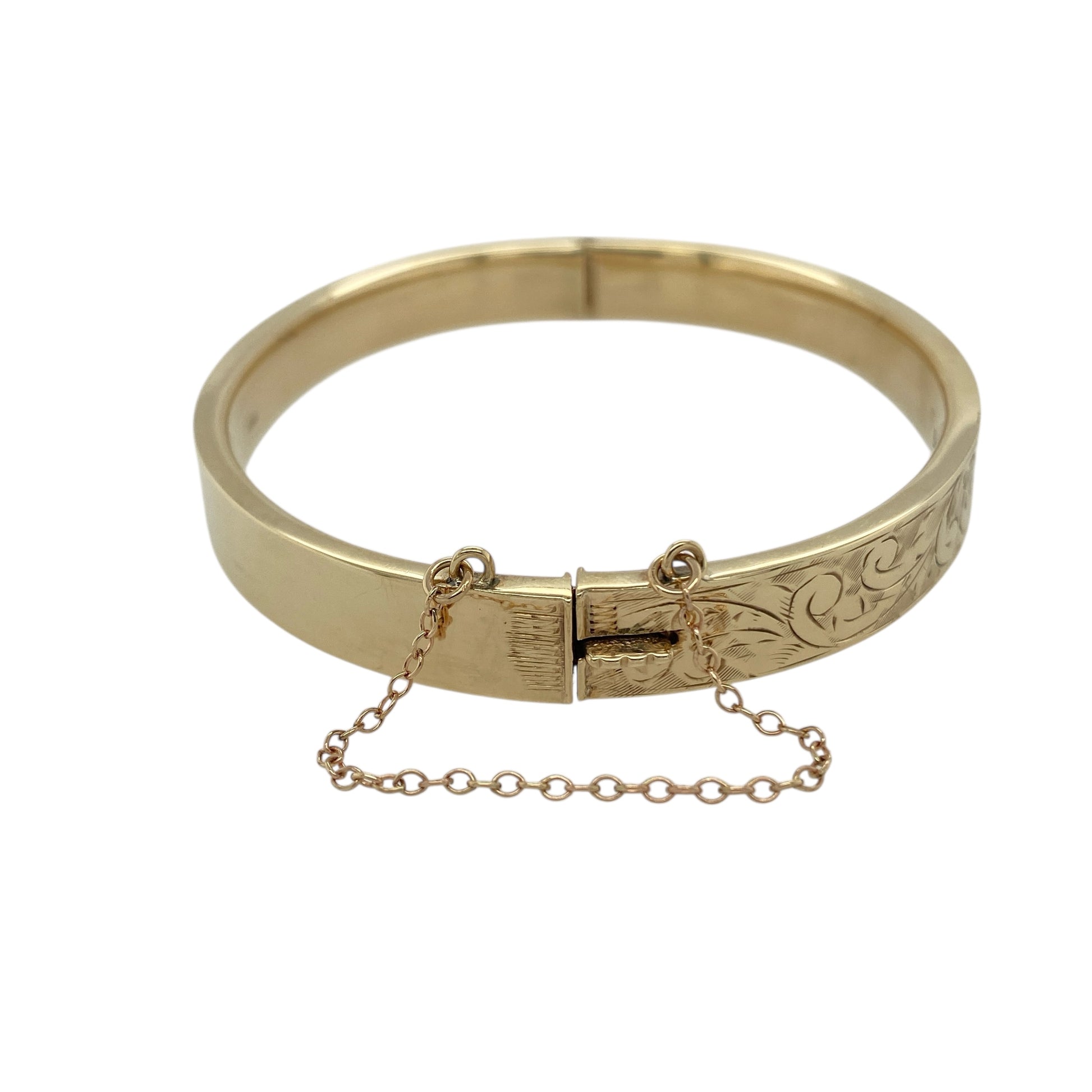 Bring refined elegance and vintage-inspired charm to your collection with this pre-owned 9ct yellow gold patterned hinged bangle, combining timeless design with thoughtful detail—perfect for special occasions or sophisticated everyday wear.

Design: The bangle features an intricate patterned finish across its 8mm width, complemented by a secure hinge fastening and safety chain for added confidence and ease of wear.
