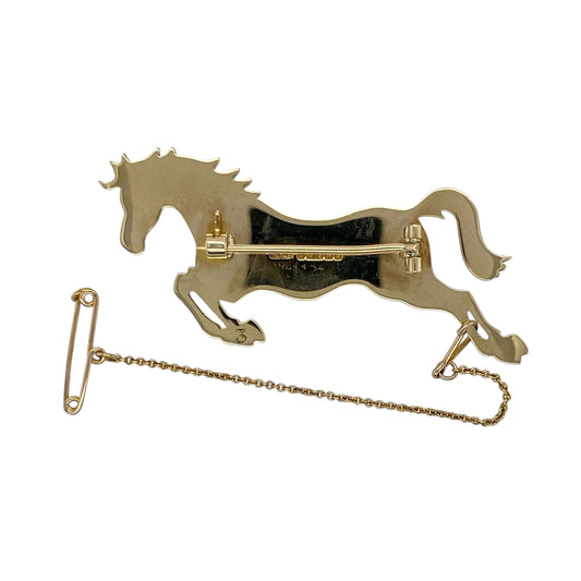 Bring equestrian elegance and timeless design to your collection with this pre-owned 9ct yellow gold large horse brooch—perfect for collectors and lovers of classic statement jewellery.

Design: The brooch features a beautifully detailed horse in motion, capturing a sense of grace and strength. The polished finish enhances the intricate contours, giving the piece depth and a lifelike appearance.