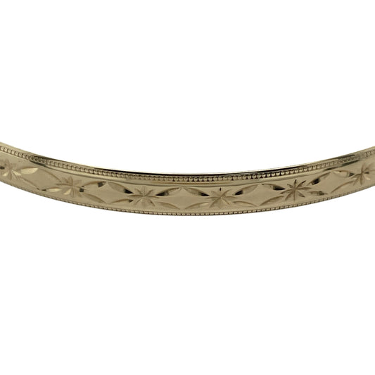 Bring refined elegance and timeless detail to your jewellery collection with this pre-owned 9ct solid yellow gold patterned bangle—perfect for adding a touch of classic luxury to any occasion.

Design: The bangle features a 5mm-wide band adorned with an intricate patterned finish, offering subtle texture and visual depth. The smooth polished edges provide balance and comfort, enhancing its elegant appearance.