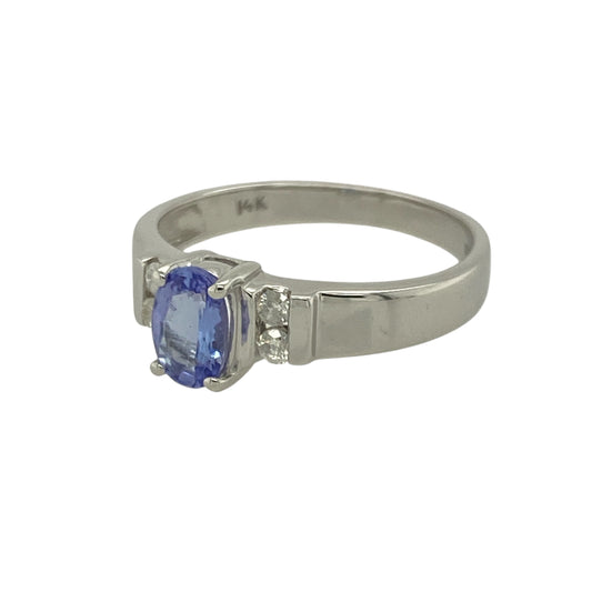 Bring elegant colour and refined sparkle to your collection with this pre-owned 14ct white gold diamond and tanzanite set ring—perfect for adding a touch of sophistication and luxury to any occasion.

Design: The ring features a captivating 6mm by 4mm oval-cut tanzanite at its centre, displaying the stone’s signature violet-blue hues. Two brilliant-cut diamonds are set on each side, enhancing the tanzanite’s colour and creating a graceful, balanced design.