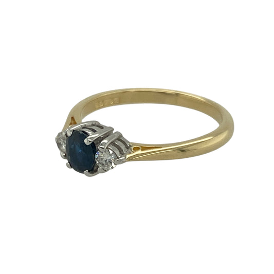Bring timeless elegance and rich colour to your collection with this pre-owned 18ct yellow gold diamond and sapphire set trilogy ring—perfect for special occasions or as a classic everyday treasure.

Design: The ring features a 5mm by 4mm oval-cut sapphire at the centre, flanked by a small brilliant-cut diamond on either side. The trilogy arrangement symbolises past, present, and future—creating a meaningful and sophisticated design.