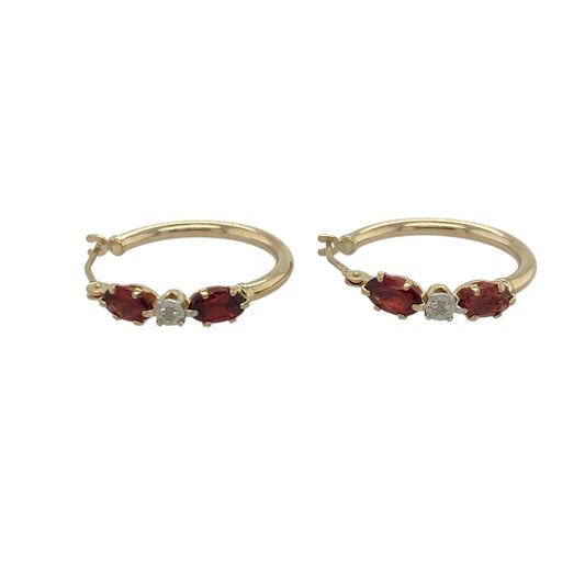 Bring rich colour and elegant sparkle to your look with these pre-owned 9ct yellow gold diamond and garnet set hoop creole earrings—perfect for adding timeless warmth to any outfit.

Design: Each earring features a 5mm by 3mm oval-cut garnet, radiating deep red tones that symbolise passion and strength. The garnets are accented with sparkling diamonds, adding brilliance and contrast to the classic creole design.