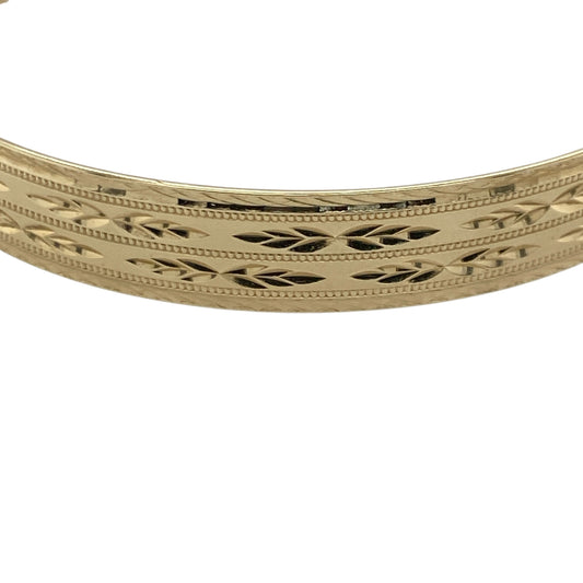 Bring timeless design and refined detail to your collection with this pre-owned 9ct solid yellow gold patterned expanding bangle—perfect for everyday elegance or special occasions.

Design: The bangle features a 9mm-wide band with an intricate patterned finish, adding depth and texture to its classic form. The expanding design allows for easy wear while maintaining a sleek, elegant profile.