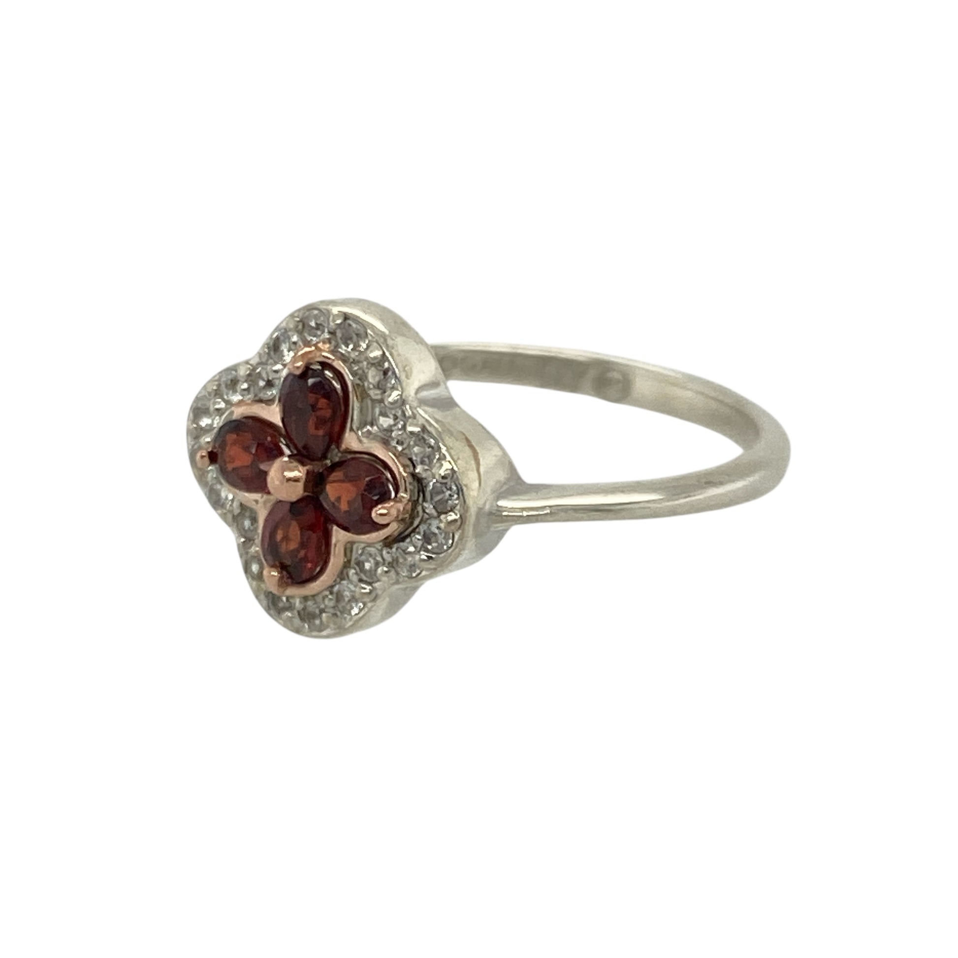 Bring regal elegance and refined sparkle to your collection with this pre-owned 925 silver and 9ct rose gold white topaz and garnet set Clogau Tudor Court flower style ring—perfect for adding a touch of heritage-inspired beauty to any occasion.

Design: The ring features an intricate flower-style design at the front, measuring 11mm high, inspired by the ornate architecture of the Tudor period.