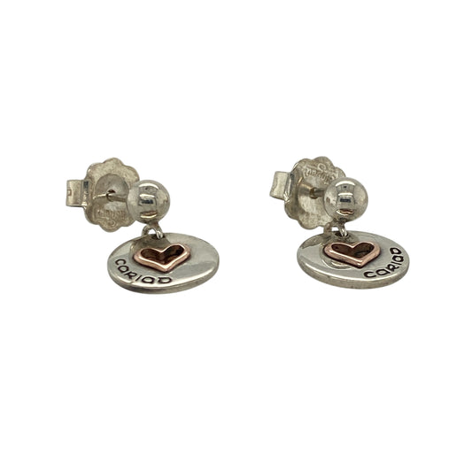 Bring romantic charm and elegant movement to your look with these pre-owned 925 silver and 9ct rose gold Clogau Cariad heart drop earrings—perfect for expressing love and timeless style.

Design: Each earring features an open heart design that gently dangles, symbolising love and affection. The combination of sterling silver and warm rose gold detailing creates a beautiful contrast and adds a touch of sophistication.