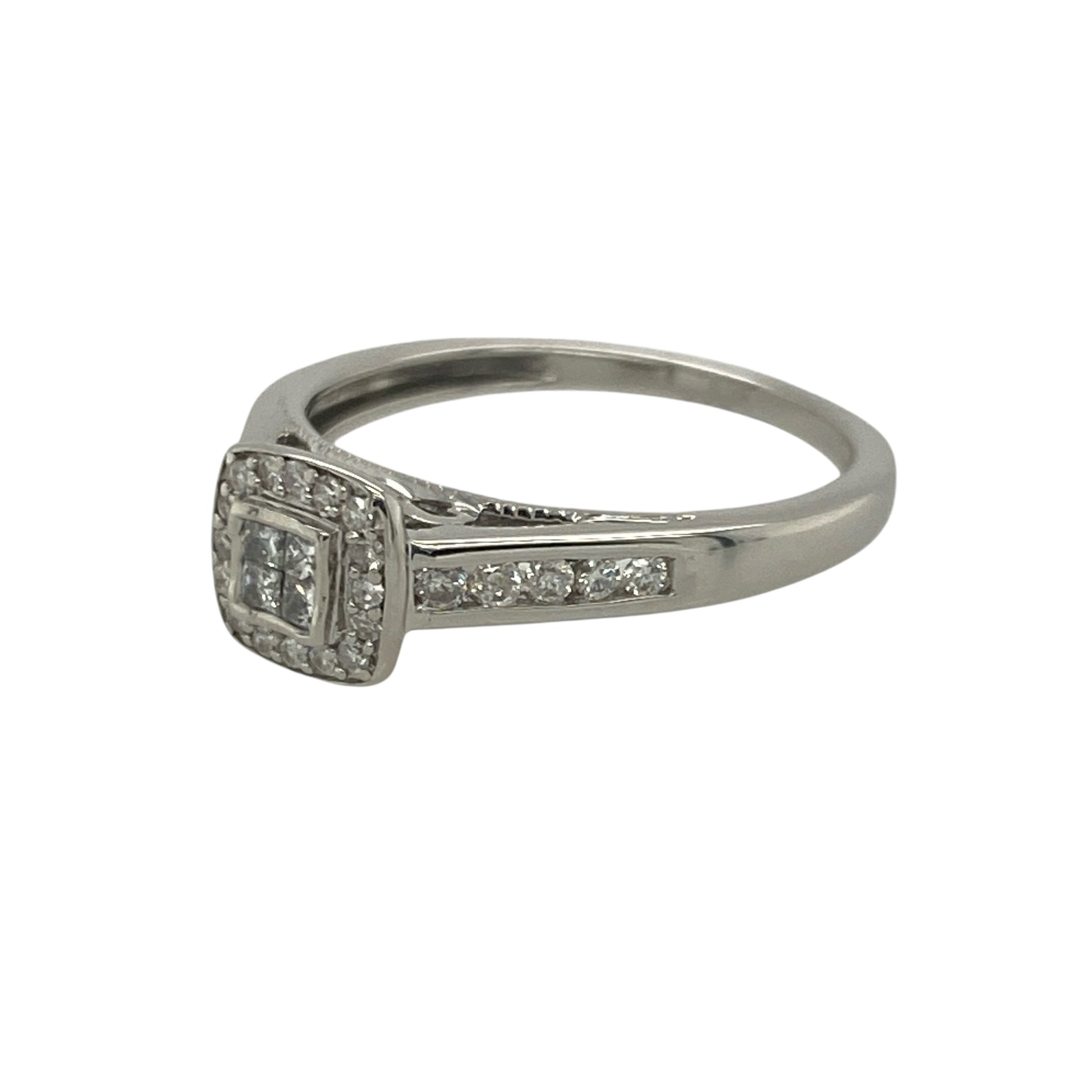 Add radiant sparkle and modern elegance to your collection with this pre-owned 9ct white gold diamond set princess cut halo ring — a luxurious design that captures timeless beauty with contemporary flair.

Design: The ring features four princess-cut diamonds at the centre, creating a square cluster framed by a halo of brilliant-cut diamonds. Additional diamonds set along the shoulders enhance the ring’s brilliance and symmetry. The design offers approximately 0.25 carats of diamond content in total
