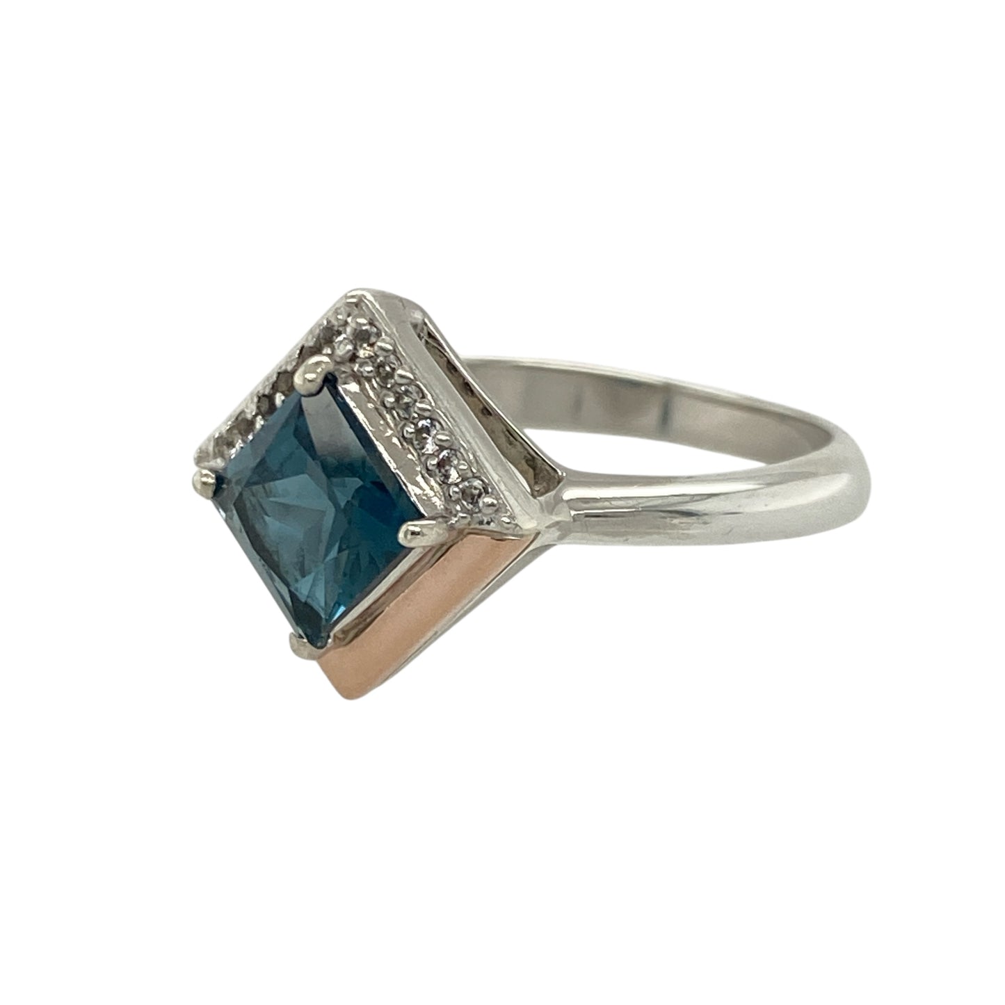 Add a touch of elegance and romance to your collection with this pre-owned 925 silver and blue and white topaz Clogau Kensington Love ring — a beautifully detailed piece inspired by timeless sophistication.

Design: The ring features a striking 6mm by 6mm square-cut blue topaz at the centre, accented by sparkling white topaz stones that enhance its brilliance and symbolise enduring love.
