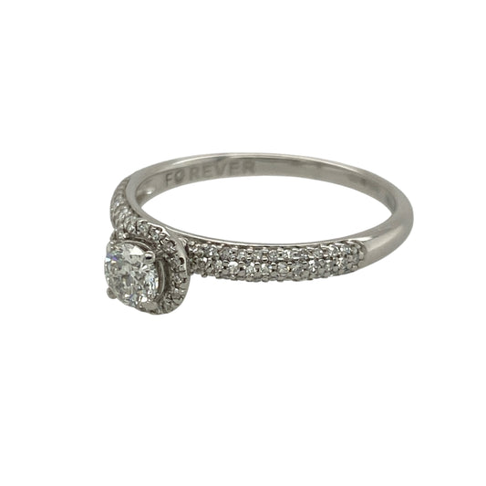Pre-owned 18ct White Gold &amp; Diamond Halo Ring with diamond set shoulders and a brilliant cut diamond in the center. The ring is in size O with the wight 2.30 grams. There is approximately 0.50ct of diamond content set in total with approximate clarity Si2 and colour K - M