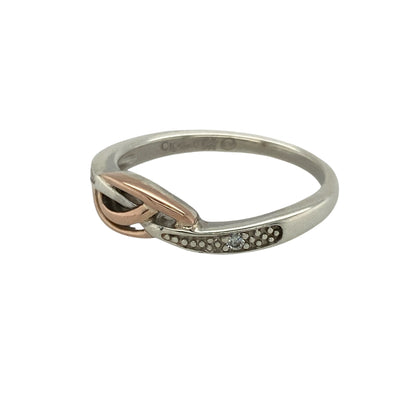 Add subtle sparkle and timeless elegance to your collection with this pre-owned 925 silver and 9ct rose gold Clogau ring, offering refined style and everyday sophistication.

Design: The ring features a classic band design measuring 5mm wide at the front, accented with delicate diamond detailing that adds a touch of brilliance without overpowering its sleek form.